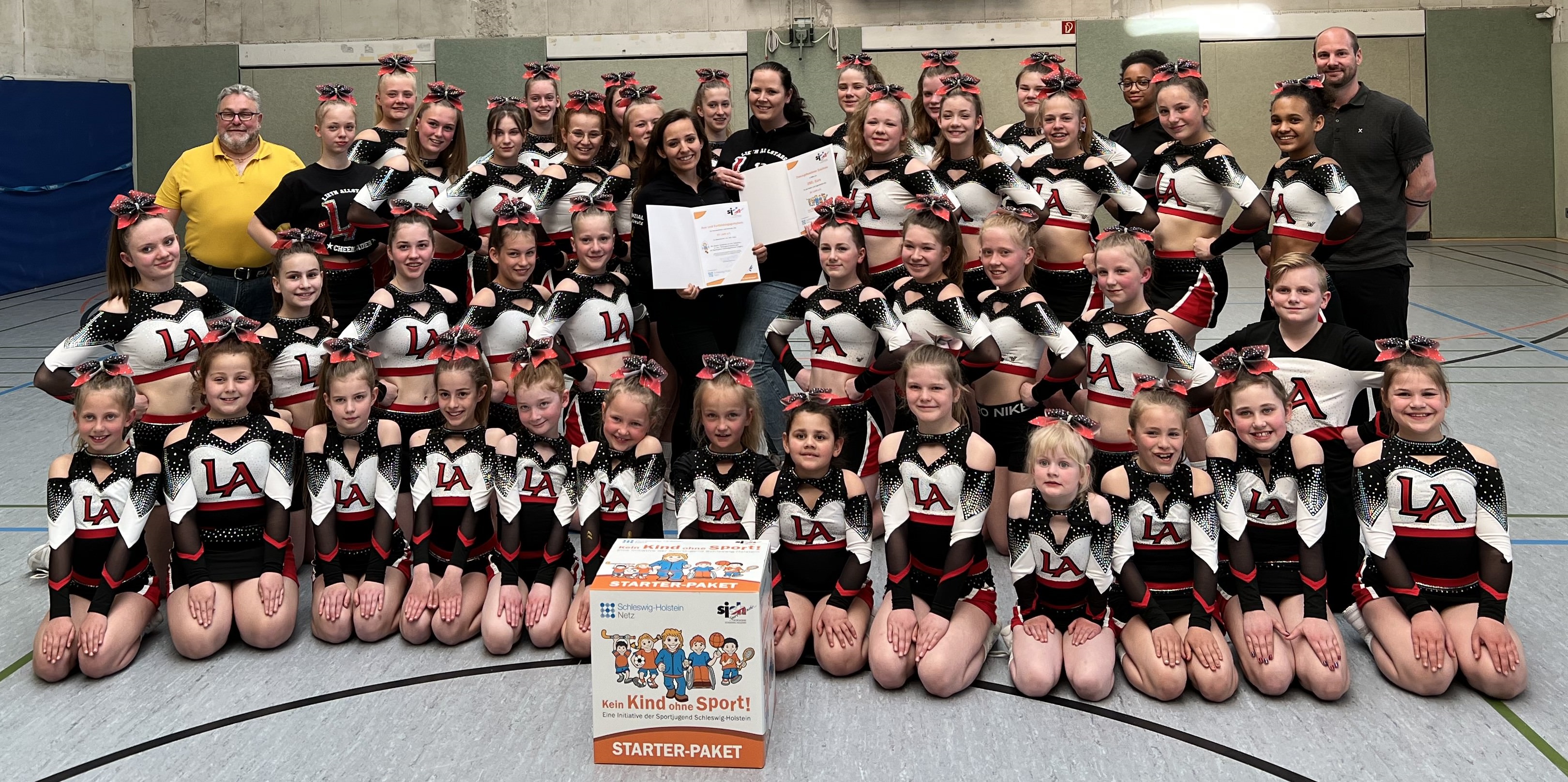 Die Cheerleading-Teams der Spielvereinigung Lieth konnten sich im Rahmen Ihres Trainings über das Starter-Paket freuen. Stefan König (Vorsitzender der Sportjugend im Kreissportverband Pinneberg, links im Bild) und Christoph Menge (stellvertretender Vorsitzender der Sportjugend Schleswig-Holstein, rechts im Bild) zeichneten die Sportlerinnen und ihre Trainerinnen aus.