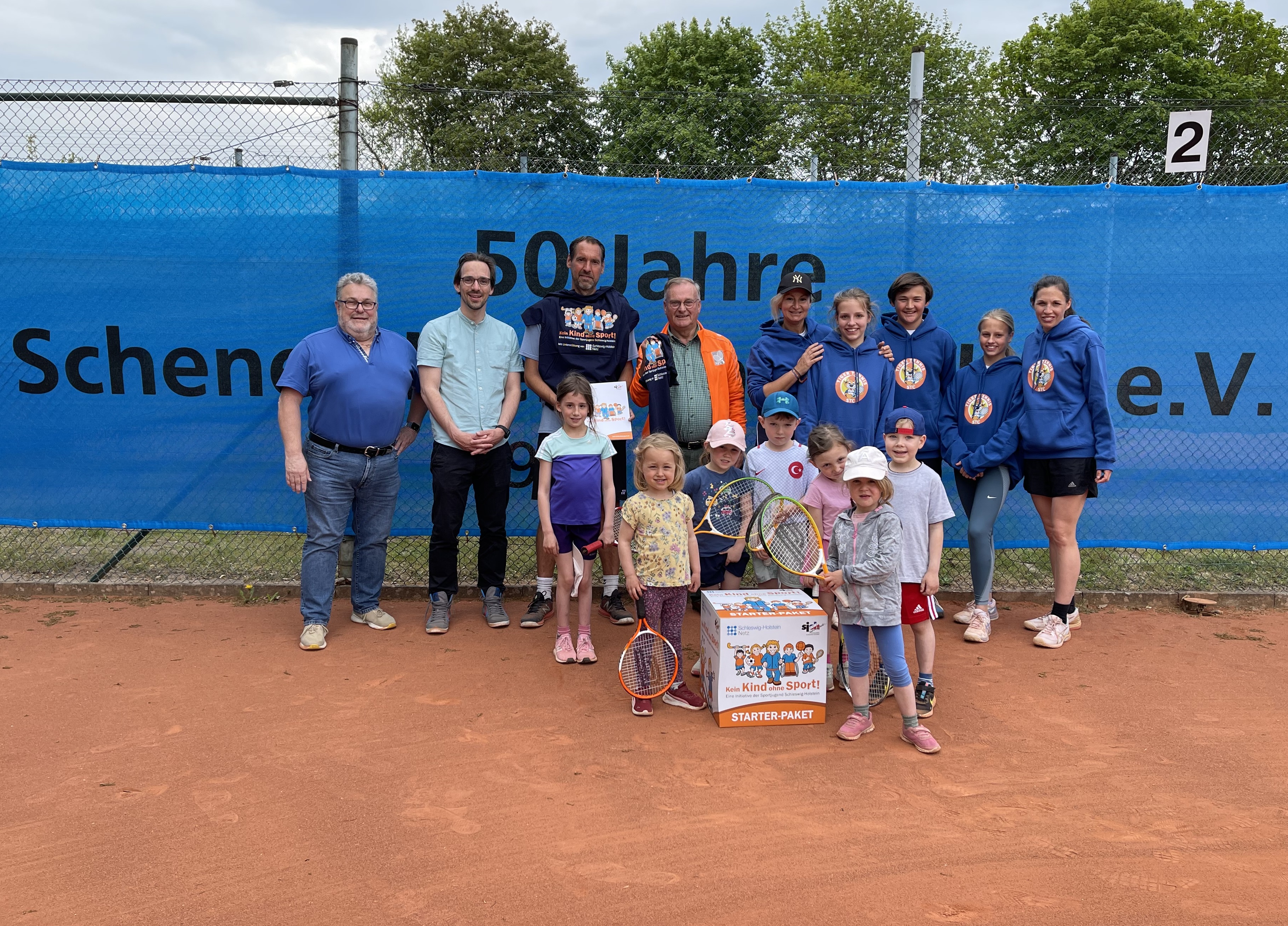 Hintere Reihe (v.l.n.r.): Stefan König (Vorsitzender der Sportjugend im Kreissportverband Pinneberg), Jakob Voß (Jugendbildungsreferent der Sportjugend Schleswig-Holstein), Oliver Warncke-Wittekind (Trainer des Schenefelder TC), Dr. Hartmut Rosengarten (Sportwart des Schenefelder TC) und Elena Frolova (Jugendwartin des Schenefelder TC) gemeinsam mit dem Starter-Paket „Kein Kind ohne Sport!“ und den Aktiven der Ballsportschule des Schenefelder TC.