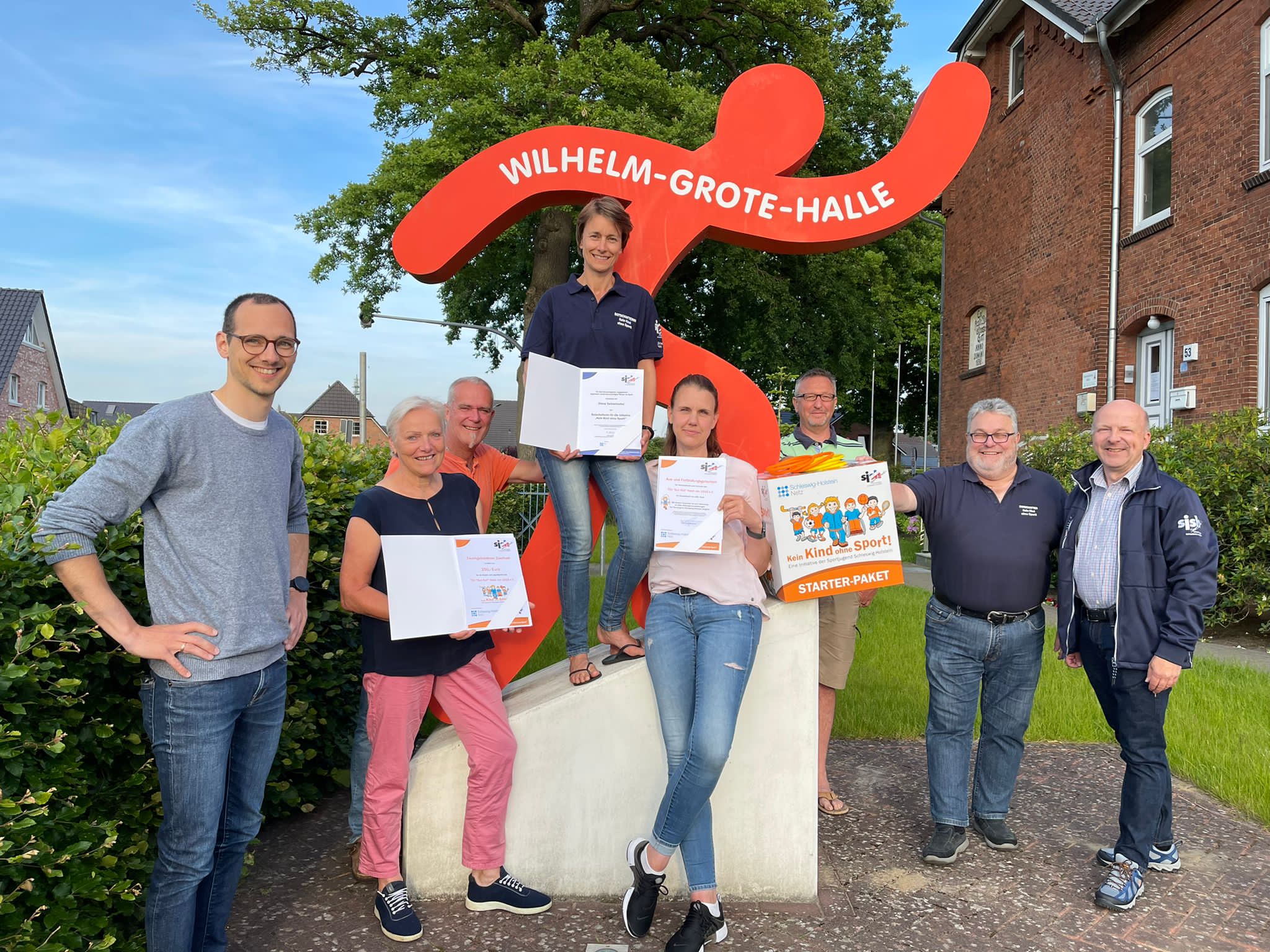 Jannik Olsson (Kommunalmanager der Schleswig-Holstein Netz AG; links im Bild) überreichte das Starter-Paket der Initiative „Kein Kind ohne Sport!“ gemeinsam mit Stefan König (Vorsitzender der Sportjugend im Kreissportverband Pinneberg; zweite Person von rechts) und Dietmar Rohlf (stellvertretender Vorsitzender der Sportjugend Schleswig-Holstein; rechts im Bild) an die Verantwortlichen des TSV Heist.