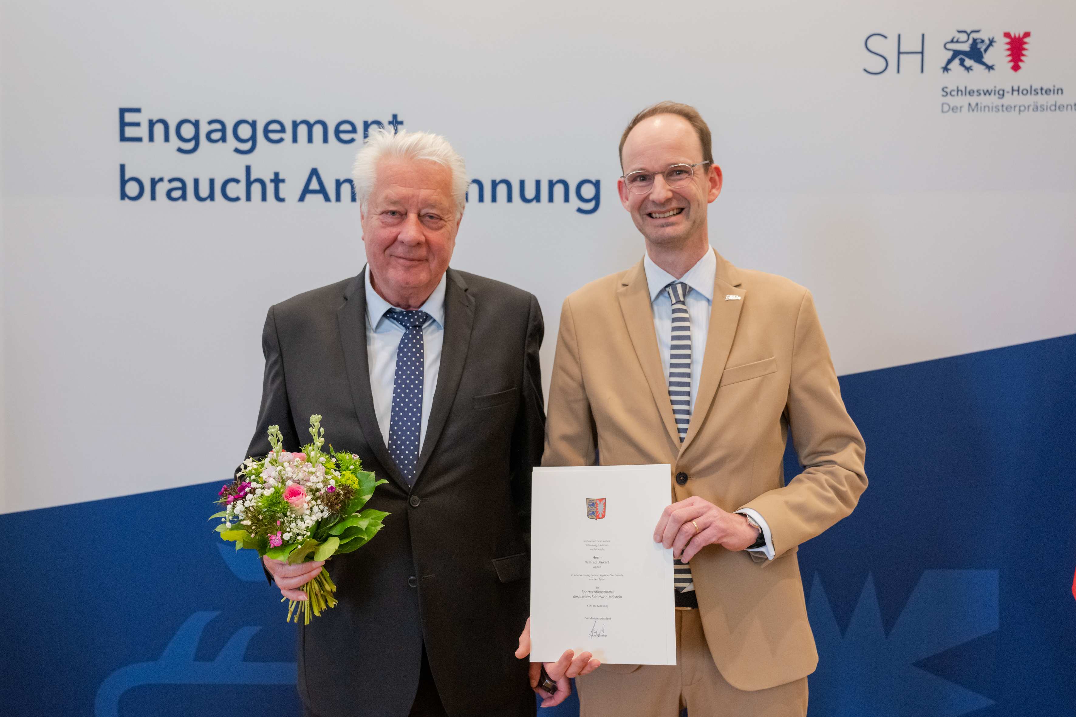 Wilfred Diekert (l.) erhält aus den Händen von Tilo von Riegen (r.) die Sportverdienstnadel des Landes Schleswig-Holsteins am 16.05.2023 in Kiel - Foto: Frank Peter