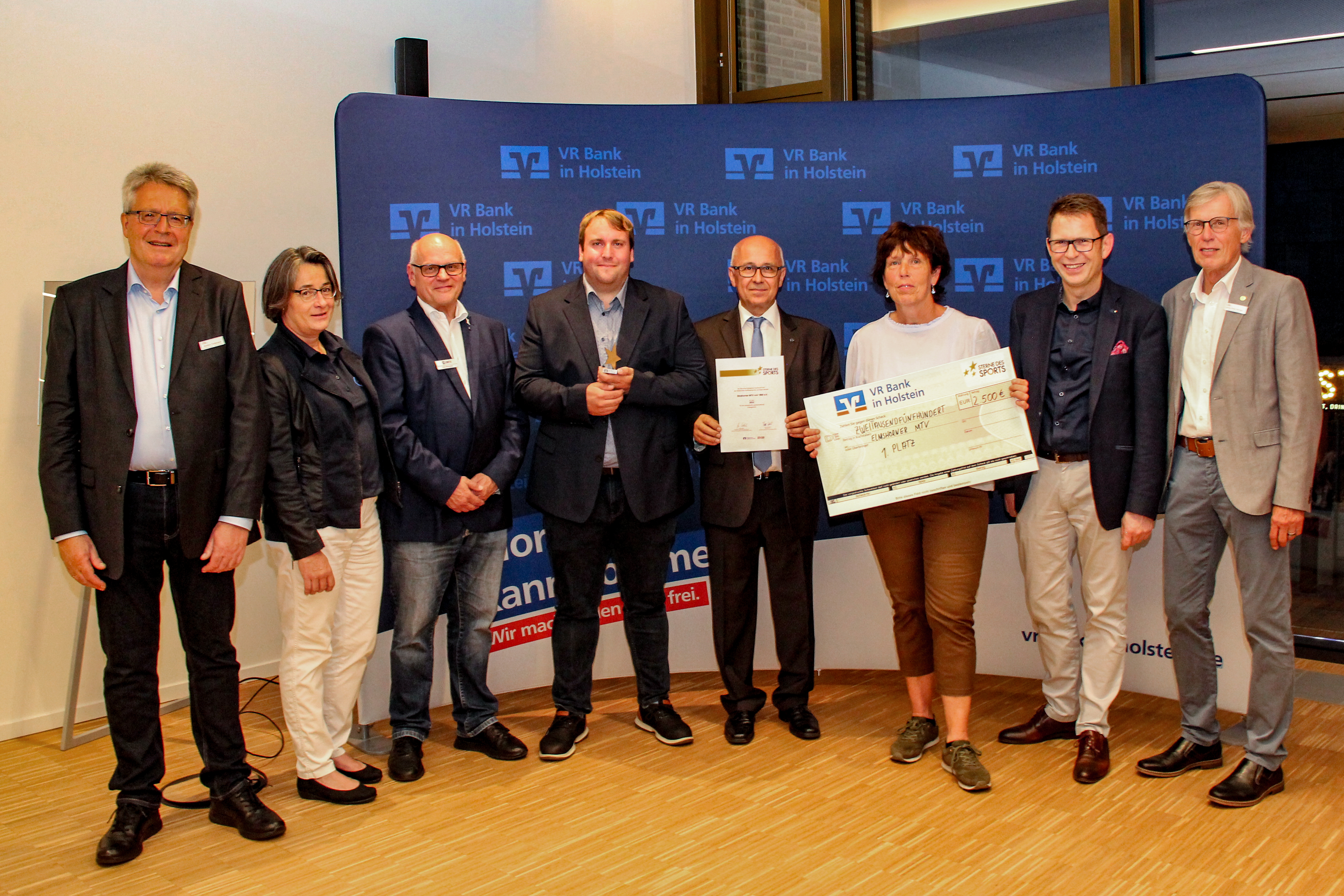 Der Elmshorner MTV gewinnt 2022 den Bronzenen Stern des Sports! Die VR Bank in Holstein, die Bürgerstiftung VR Bank in Holstein und der KSV Pinneberg gratulieren! - v.l.n.r. Karsten Tiedemann (KSV), Bettina Fischer (Bürgerstiftung), Uwe Altemeier (EMTV), Timo Schirmacher (EMTV), Mehmet Karakavak (EMTV), Maren Caffi (EMTV), Uwe Augustin (VR Bank), Sönke-Peter Hansen (KSV) - Foto: VR Bank in Holstein