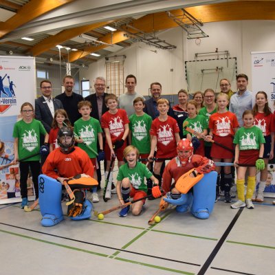 Schülerinnen und Schüler (5.-8. Klassen) der Johannes-Brahms-Schule in Pinneberg freuen sich über das außerunterrichtliche Hockey-Angebot, das der VfL Pinneberg als Kooperationspartner im Rahmen des LSV-Projekts "Schule+Verein" an der Schule anbietet. Hier gemeinsam mit Vertreterinnen und Vertretern von Schule, Verein, AOK Nordwest, Sparkasse Südholstein sowie Kreissportverband Pinneberg und Landessportverband Schleswig-Holstein. - Foto: LSV/Stefan Arlt