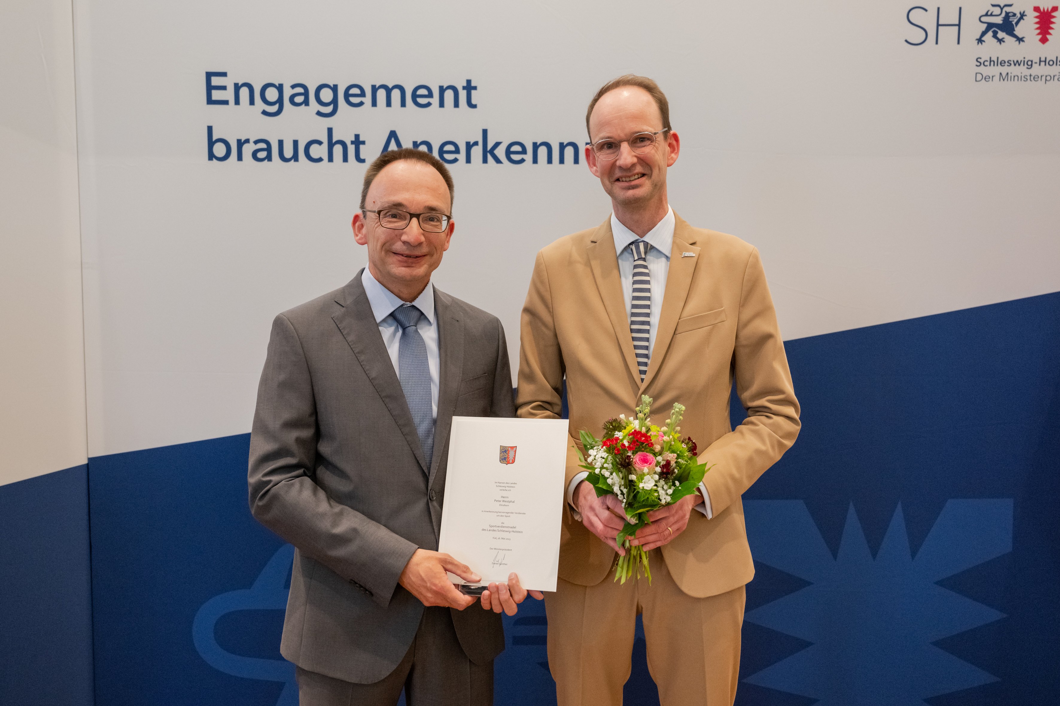 Peter Westphal (l.) erhält aus den Händen von Tilo von Riegen (r.) die Sportverdienstnadel des Landes Schleswig-Holsteins am 16.05.2023 in Kiel - Foto: Frank Peter