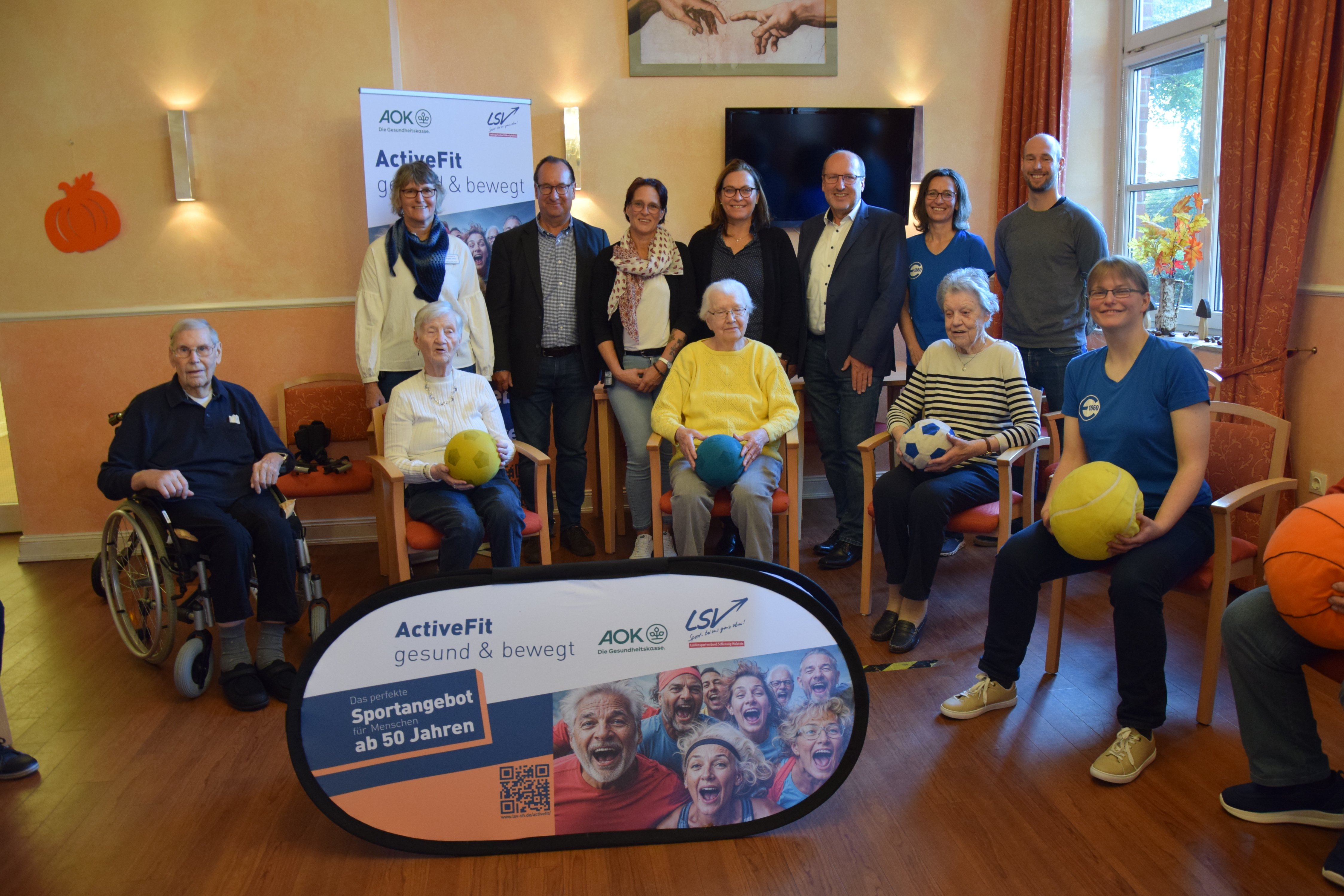 Teilnehmende des vom Elmshorner MTV angebotenen ActiveFit-Kurses im Johanniter-Haus Lindenpark mit Vertreterinnen und Vertretern der Senioreneinrichtung, des EMTV, des Landessportverbandes Schleswig-Holstein, des Kreissportverbandes Pinneberg sowie der AOK NordWest - Foto: Stefan Arlt