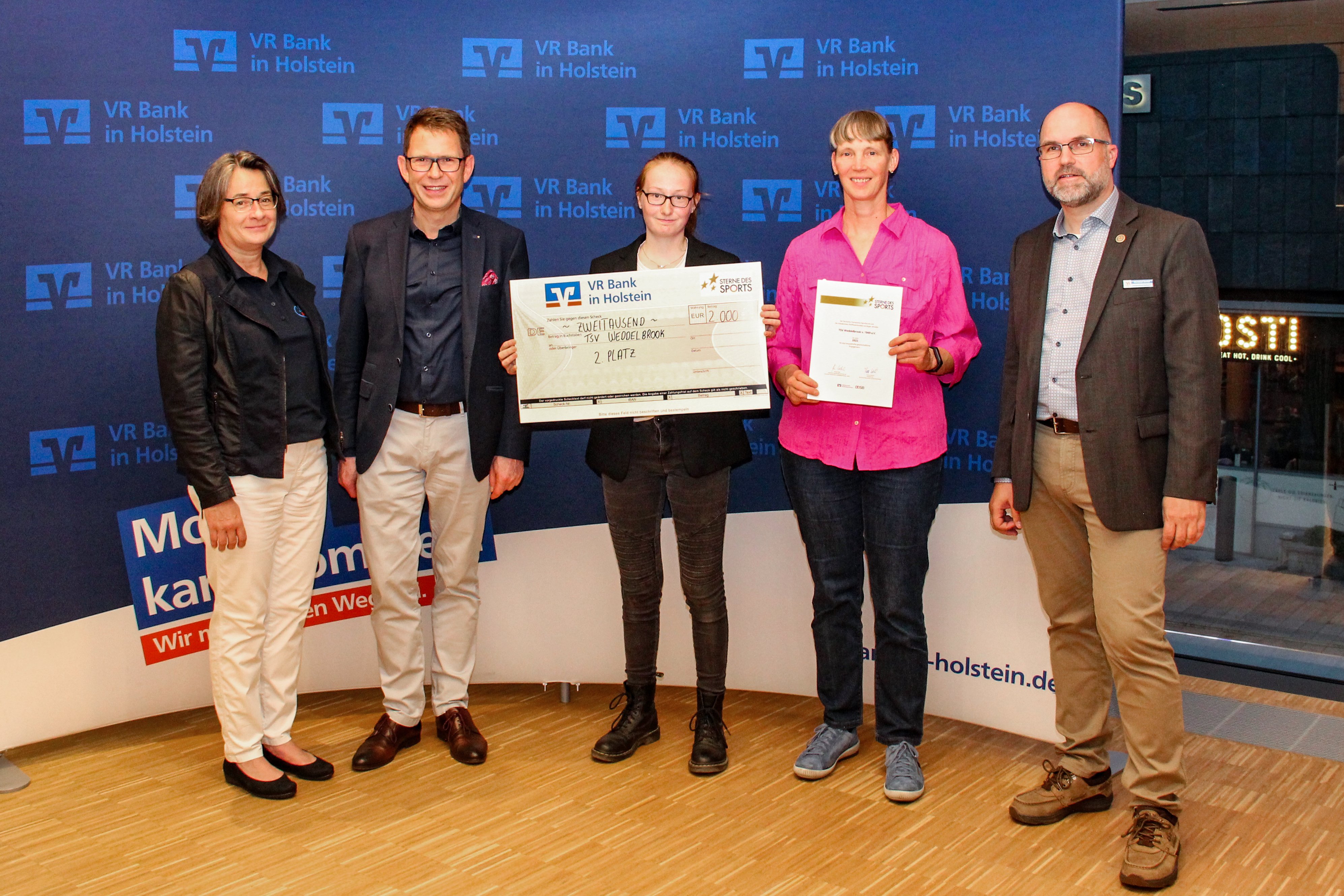 Der TSV Weddelbrook belegt 2022 den zweiten Platz bei den Sternen des Sports! Bettina Fischer (l. Bürgerstiftung), Uwe Augustin (2.v.l., VR Bank) und Christian Detlof (r., KSV Segeberg) übergeben die Urkunde und das Preisgeld. - Foto: VR Bank in Holstein Der TSV Weddelbrook belegt 2022 den zweiten Platz bei den Sternen des Sports! Bettina Fischer (l. Bürgerstiftung), Uwe Augustin (2.v.l., VR Bank) und Christian Detlof (r., KSV Segeberg) übergeben die Urkunde und das Preisgeld. - Foto: VR Bank in Holstein